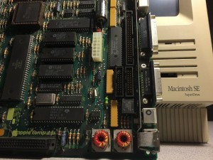 Macintosh SE Logic Board leaned against front of Macintosh SE SuperDrive machine case.