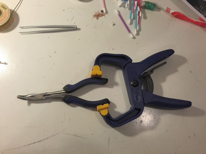 Makeshift clamp used to hold capacitors for pre-tinning.